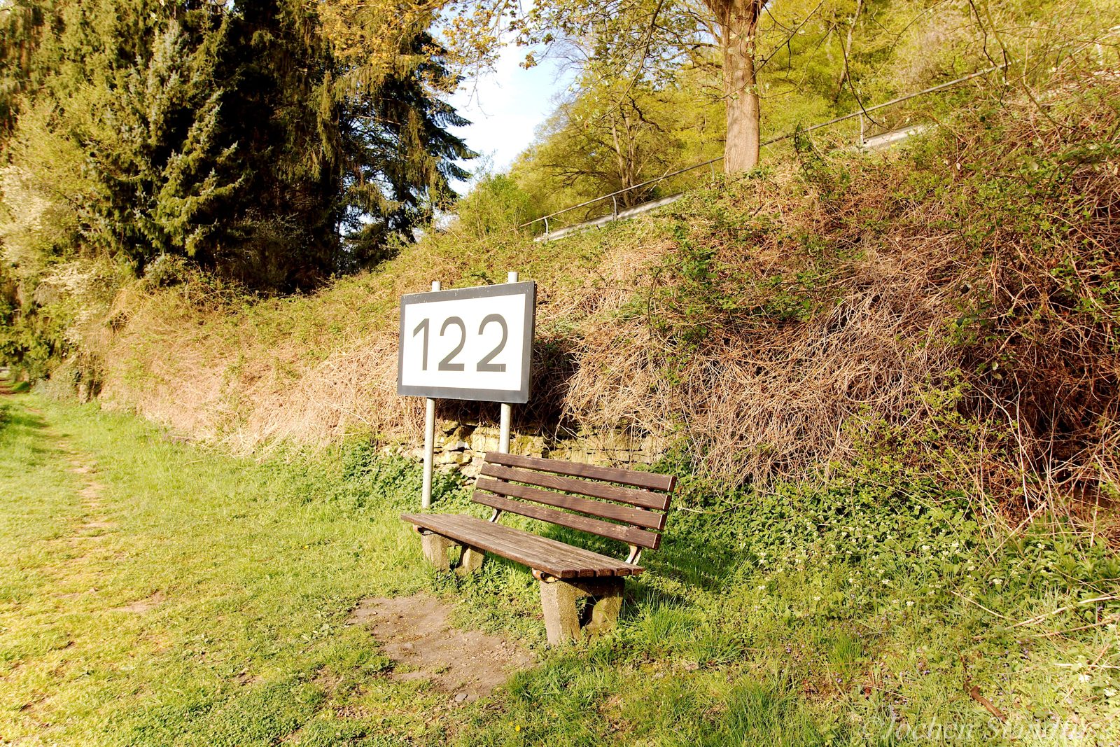 Holzbank am Lahnufer beim Schild Lahnkilometer 122, Brückenrundweg Dausenau